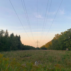 Electricity pylon on field against sky