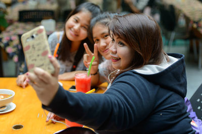Portrait of young woman sitting on table