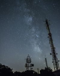 Low angle view of silhouette telecommunication tower against sky at night