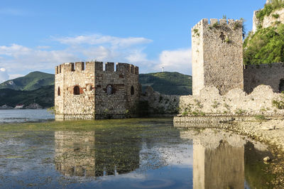 Castle by water against sky