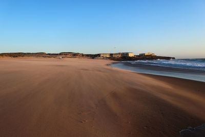 Scenic view of beach against clear blue sky