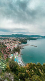 High angle view of townscape by sea against sky