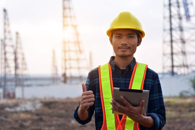 Portrait of smiling man using smart phone at construction site