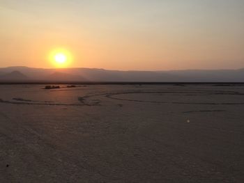 Scenic view of desert against sky during sunset