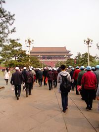 Rear view of people walking on building