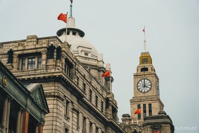 Low angle view of clock tower amidst buildings in city