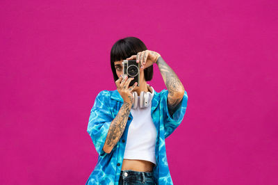 Caucasian girl with short hair tattooed on pink background