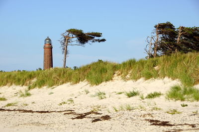 Lighthouse on field against sky