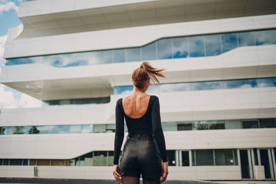 Rear view of woman standing against building