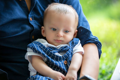 Midsection of father carrying cute son in cafe