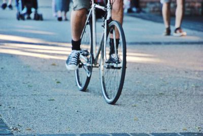 Low section of man cycling on road