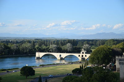 Arch bridge over river against sky