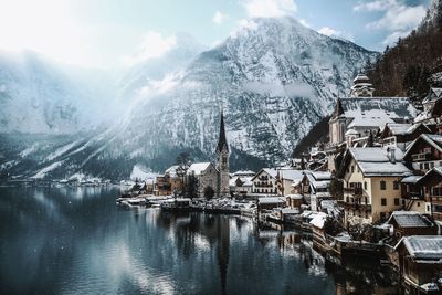 Scenic view of townscape by snow covered mountains