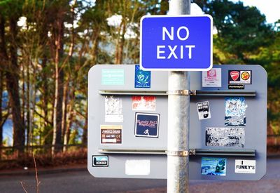 Close-up of information sign against blue sky