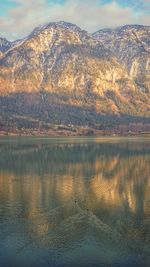 Scenic view of lake by mountains against sky