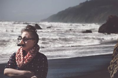 Woman standing on beach wearing mask