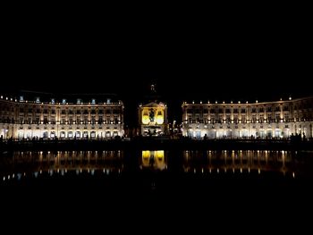 Reflection of building in lake at night