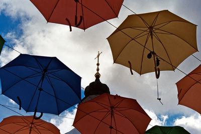 Low angle view of umbrellas hanging against sky