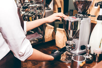 Midsection of woman having coffee at cafe