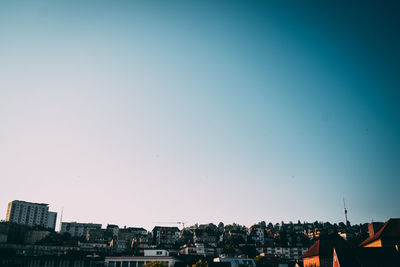 Buildings in city against clear blue sky