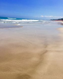 Scenic view of beach against blue sky