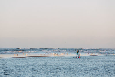 Man standing on beach against clear sky