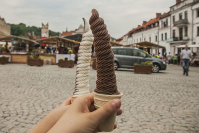 Hands of women holding ice cream in city