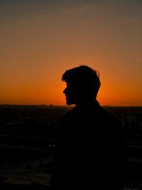 Silhouette man standing against sky during sunset