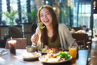 Portrait of young woman having food at restaurant