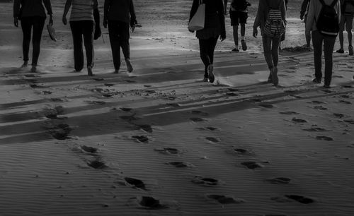 Low section of people standing on beach