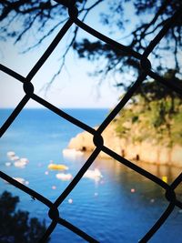 Close-up of chainlink fence against sky