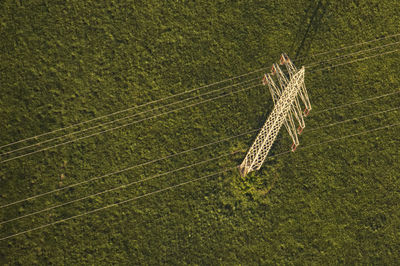 High angle view of electricity pylon on grassy field 