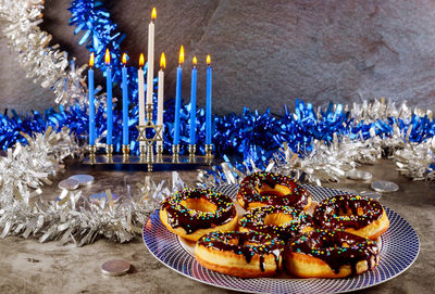 High angle view of cake with illuminated candles on table