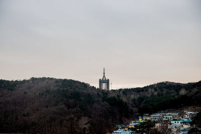 Tower amidst trees against sky