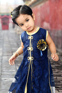 Portrait of cute girl standing on footpath