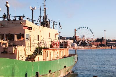 Ship moored in sea against clear blue sky