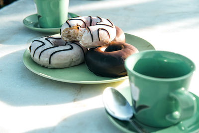 Composition of aromatic hot drink and tasty donuts on table