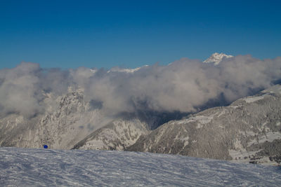 Scenic view of snowcapped mountains against blue sky