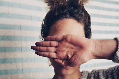 Close-up of woman covering eyes