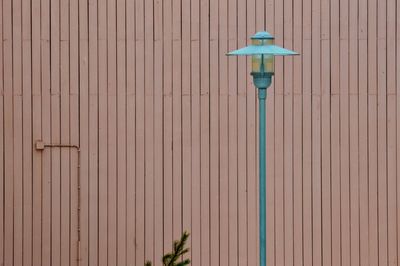 Low angle view of lamp against wall