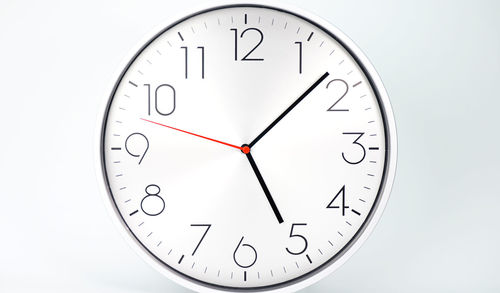 Close-up of clock over white background