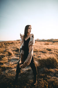 Woman wearing sunglasses on field against sky