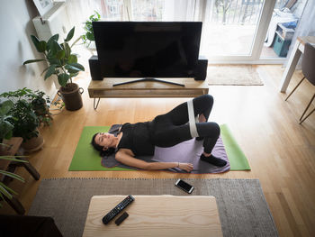 High angle view of woman exercising at home