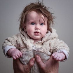 Portrait of cute baby boy against white background