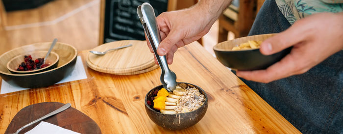 Cropped hand of person preparing food on table