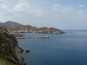 Scenic view of sea by mountains against sky