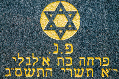 Close-up of yellow sign on road