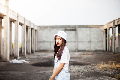 Portrait of woman standing against wall