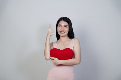 Portrait of a smiling young woman against white background