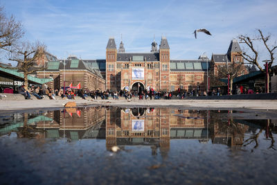 Group of people in front of buildings against sky